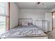 Bright bedroom with a rustic wood-trimmed bed, soft gray bedding, and a view of the outdoors at 35427 Welch Trl, Elizabeth, CO 80107