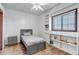 Cozy bedroom with gray wood-look floors, twin bed, built-in shelving, and natural light at 35427 Welch Trl, Elizabeth, CO 80107