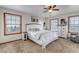 Sunlit bedroom featuring a white bed frame, wood-trimmed windows, and neutral decor at 35427 Welch Trl, Elizabeth, CO 80107