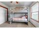 Cozy bedroom featuring a bunk bed, neutral decor, and a large window at 35427 Welch Trl, Elizabeth, CO 80107