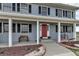 Inviting front porch with seating, a red front door, and decorative landscaping, creating a warm and welcoming entrance at 35427 Welch Trl, Elizabeth, CO 80107