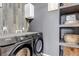 A convenient laundry room area with side by side washer and dryer and gray wood look accent wall at 35427 Welch Trl, Elizabeth, CO 80107