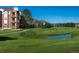 Scenic view of community green space, walking path, pond and the condo building at 2896 W Riverwalk Cir # 204, Littleton, CO 80123