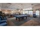 Spacious game room featuring two blue pool tables, ping pong, and comfortable lounge seating at 2896 W Riverwalk Cir # 204, Littleton, CO 80123