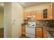 Kitchen with light wood cabinets, granite countertops, and appliances at 2896 W Riverwalk Cir # 204, Littleton, CO 80123