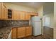 Kitchen with light wood cabinets, granite countertops, and appliances at 2896 W Riverwalk Cir # 204, Littleton, CO 80123