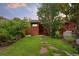 Grassy backyard with patio, mature trees, and green landscape at 1215 Jackson St, Denver, CO 80206