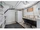 Unfinished basement with utility sink, laundry, shelving, and fridge at 1215 Jackson St, Denver, CO 80206