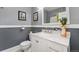 Bathroom with marble countertop, white vanity, and framed artwork at 1215 Jackson St, Denver, CO 80206