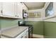 Galley kitchen featuring stainless steel gas range, microwave, white cabinets, and light countertops at 1215 Jackson St, Denver, CO 80206