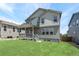 Spacious backyard with green lawn, covered patio and stairs leading to the yard at 1889 Water Birch Way, Castle Rock, CO 80108