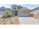 Charming two-story home with a stone facade, gray siding, and a welcoming front porch and a well manicured yard at 1889 Water Birch Way, Castle Rock, CO 80108