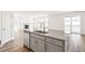 Kitchen island features a sink, dishwasher, and eat-in counter connecting to a cozy living area with fireplace at 1889 Water Birch Way, Castle Rock, CO 80108