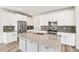 Stylish kitchen features a granite-topped island, stainless steel appliances, white cabinets, and modern backsplash at 1889 Water Birch Way, Castle Rock, CO 80108