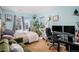 Bright bedroom featuring a comfortable bed, large windows, and a dedicated workspace with monitors and desk at 4451 S Ammons St # 4-108, Littleton, CO 80123
