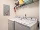 Well-equipped laundry room with a side-by-side washer and dryer, with storage shelves above at 4451 S Ammons St # 4-108, Littleton, CO 80123