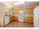 Functional kitchen with tile flooring, light wood cabinets, white appliances, and ample counter space at 4860 W 125Th Ave, Broomfield, CO 80020