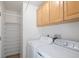 Convenient laundry room includes washer, dryer, storage cabinets, and shelving for organization at 4860 W 125Th Ave, Broomfield, CO 80020