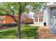 Lush backyard featuring a stone patio, mature trees, and privacy fence at 14214 Lakeview Ln, Broomfield, CO 80023