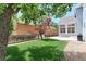 Landscaped backyard featuring a concrete patio, vibrant green grass, and wood fence at 14214 Lakeview Ln, Broomfield, CO 80023