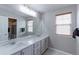 Bright bathroom featuring a double vanity and large mirror at 14214 Lakeview Ln, Broomfield, CO 80023