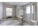 Relaxing bathroom featuring a soaking tub and a separate shower with a glass enclosure at 14214 Lakeview Ln, Broomfield, CO 80023