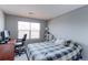 Bright bedroom features a blue plaid comforter and a convenient workspace area at 14214 Lakeview Ln, Broomfield, CO 80023