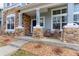 Inviting front porch with stone pillars, wicker furniture, and attractive landscaping at 14214 Lakeview Ln, Broomfield, CO 80023
