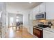 Bright kitchen featuring white cabinets, stainless steel appliances, and hardwood floors at 14214 Lakeview Ln, Broomfield, CO 80023