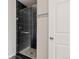Stylish bathroom with a black tiled shower and pebble floor at 18601 E Water Dr # A, Aurora, CO 80013