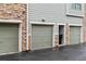 Row of garages with green doors and stone accents on a wet day at 18601 E Water Dr # A, Aurora, CO 80013