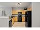 Well-lit kitchen featuring black appliances, wooden cabinets, and speckled granite countertops at 18601 E Water Dr # A, Aurora, CO 80013
