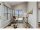 Bright home office featuring a glass desk, cowhide rug, and large windows with blinds at 18601 E Water Dr # A, Aurora, CO 80013