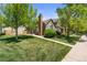 Exterior view of home featuring a lush green lawn and mature trees at 9636 W Chatfield Ave # C, Littleton, CO 80128