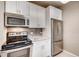 Modern kitchen features stainless steel appliances, granite countertops, and white cabinetry at 444 17Th St # 701, Denver, CO 80202