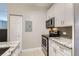 Modern kitchen featuring stainless steel appliances, granite countertops, and white cabinetry at 444 17Th St # 701, Denver, CO 80202