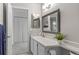 Well-lit bathroom featuring a decorative mirror, white cabinets, and tile floors at 2181 E Phillips Ln, Centennial, CO 80122