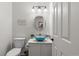 A charming powder room with a modern blue bowl sink, white cabinet, and updated fixtures at 2181 E Phillips Ln, Centennial, CO 80122