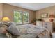 Bright bedroom with carpet, big windows to green trees, side tables, and neutral-toned decor at 2181 E Phillips Ln, Centennial, CO 80122