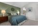 Bedroom featuring carpet, a green accent wall, and view of the adjacent bathroom at 2181 E Phillips Ln, Centennial, CO 80122
