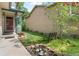 Inviting front yard showcasing lush greenery, flower beds, and a cozy bench at 2181 E Phillips Ln, Centennial, CO 80122