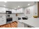 Bright kitchen features white cabinetry, stainless steel appliances, and hardwood floors at 2181 E Phillips Ln, Centennial, CO 80122