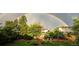 View of a backyard with lush green grass and landscaping under a rainbow at 7946 S Logan Dr, Littleton, CO 80122