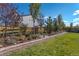 Landscaped backyard featuring a retaining wall, garden, green grass, and wood privacy fence at 1135 Basalt Ridge Loop, Castle Rock, CO 80108