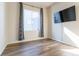 Bedroom with hardwood floors, a window with curtains, and wall-mounted television at 1135 Basalt Ridge Loop, Castle Rock, CO 80108