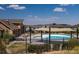 Community pool area with tables, lounge chairs, sunshades, and nearby residential houses at 1135 Basalt Ridge Loop, Castle Rock, CO 80108