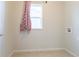 Empty laundry room featuring tile floor, window with red curtain, and hookups for washer and dryer at 1135 Basalt Ridge Loop, Castle Rock, CO 80108