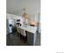 Modern kitchen with a spacious island, stylish lighting, stainless steel appliances, and a bright backsplash at 9637 E 56Th Pl, Denver, CO 80238