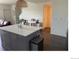 Open-concept kitchen features an island with bar seating, connecting seamlessly to the adjacent living spaces at 9637 E 56Th Pl, Denver, CO 80238