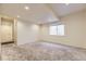 Carpeted basement with a large window allowing natural light and a utility door at 25126 E Bayaud Pl, Aurora, CO 80018